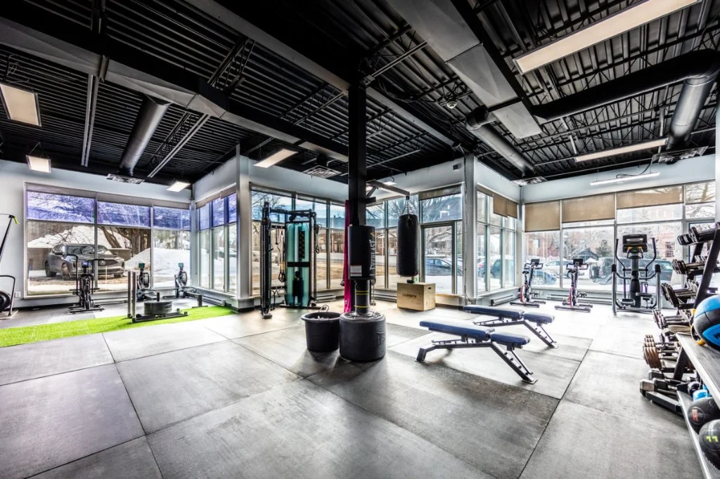 Espace d'entraînement en entreprise conçu par DNAxFIT : tapis roulants, bancs et équipements pour favoriser le bien-être des employés