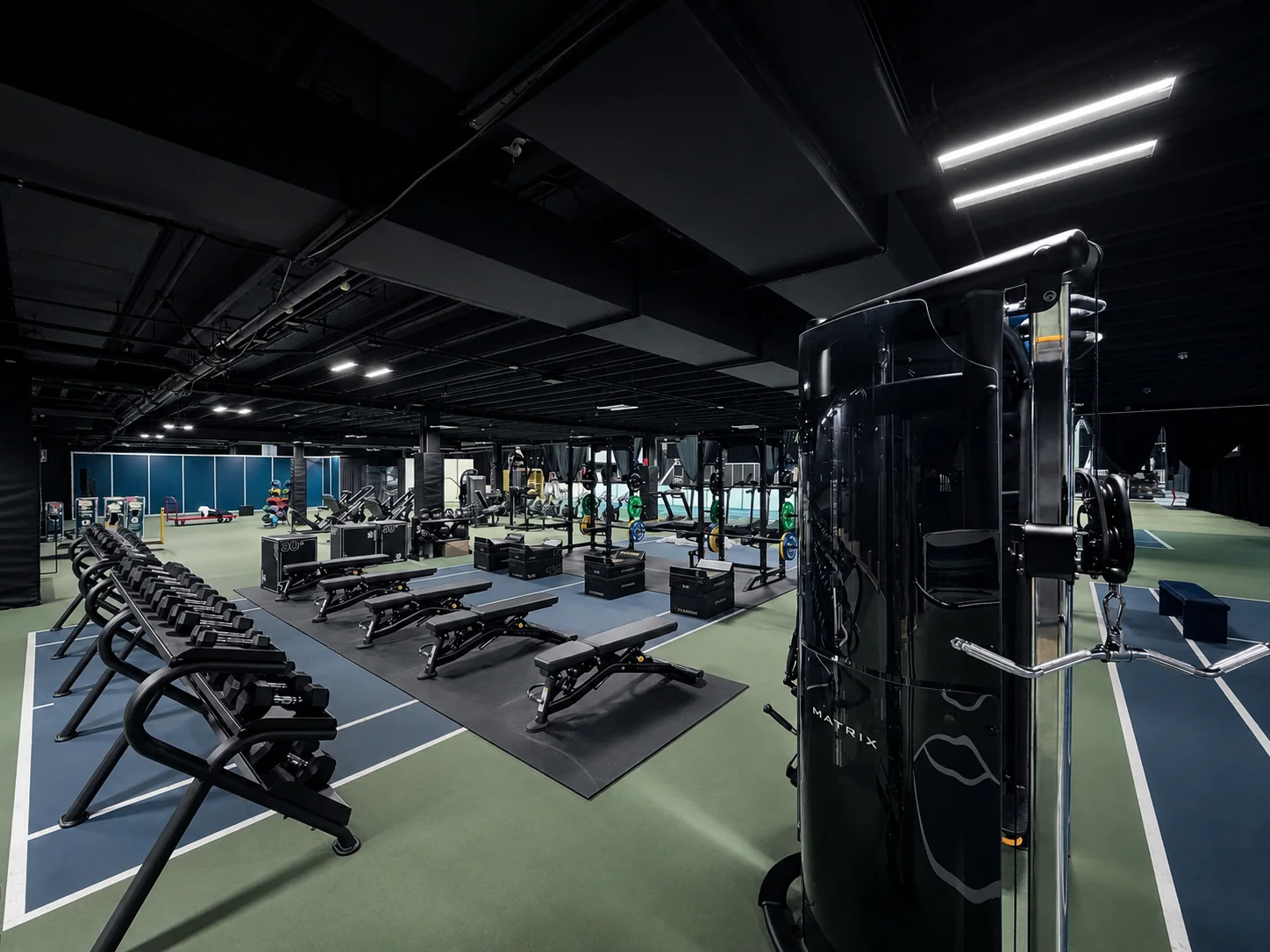 Gym institutionnel Tennis Canada avec équipements commerciaux et zones d'entraînement.