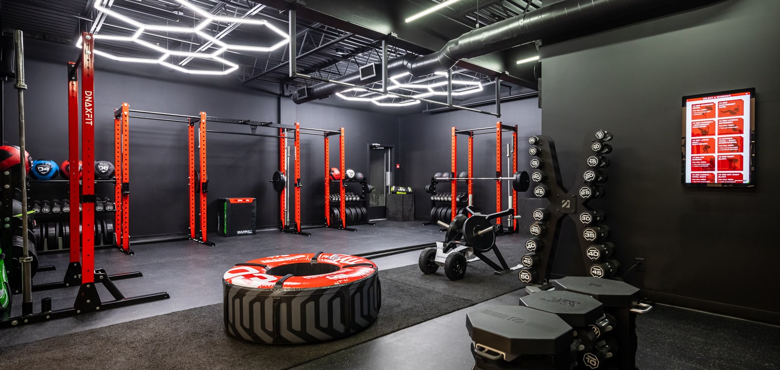 Zone d’entraînement fonctionnel avec racks rouges dans un gym commercial