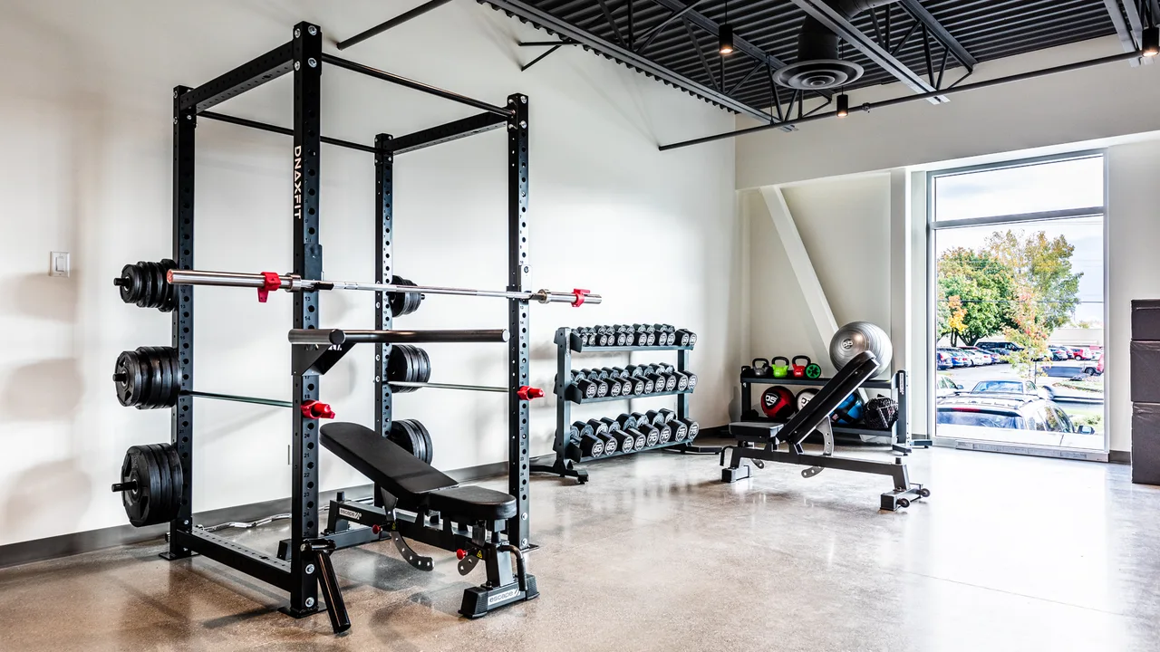Gym corporatif Archer à Granby avec rack DNAxFIT et zone de poids libres.